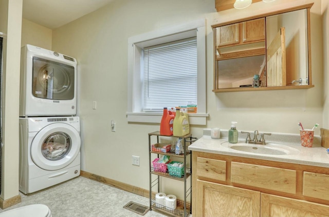 laundry room featuring stacked washer / drying machine and sink