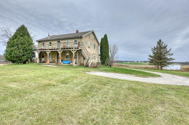 back of house featuring a yard and a wooden deck