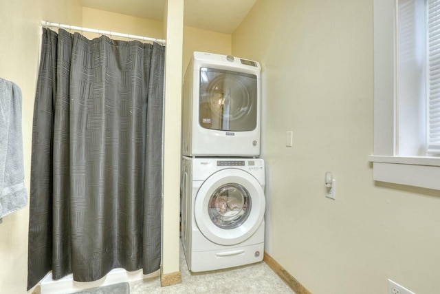 clothes washing area featuring stacked washer / drying machine