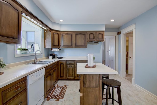 kitchen featuring a kitchen breakfast bar, sink, and white dishwasher