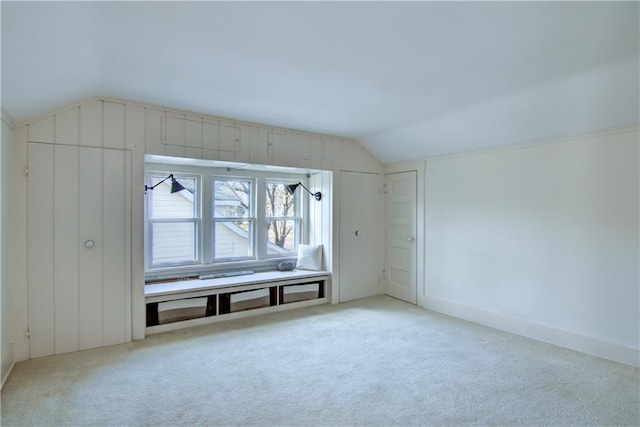 bonus room with light carpet and vaulted ceiling