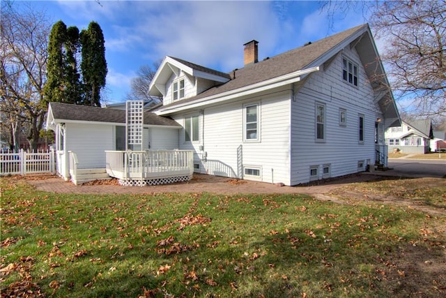 back of house with a deck and a yard