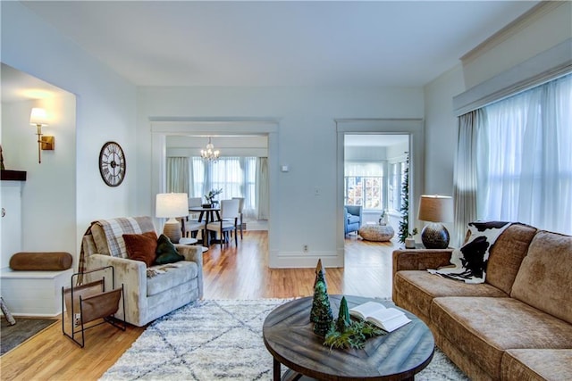 living room featuring a chandelier, plenty of natural light, and light hardwood / wood-style floors