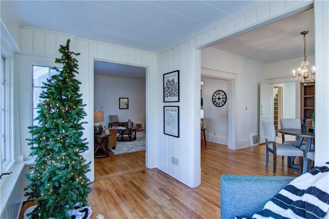 living room with a chandelier, hardwood / wood-style flooring, and ornamental molding