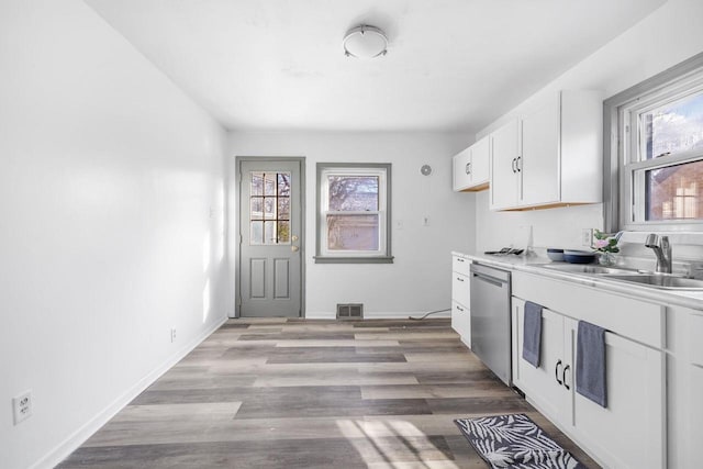 kitchen featuring dishwasher, light hardwood / wood-style floors, white cabinetry, and sink