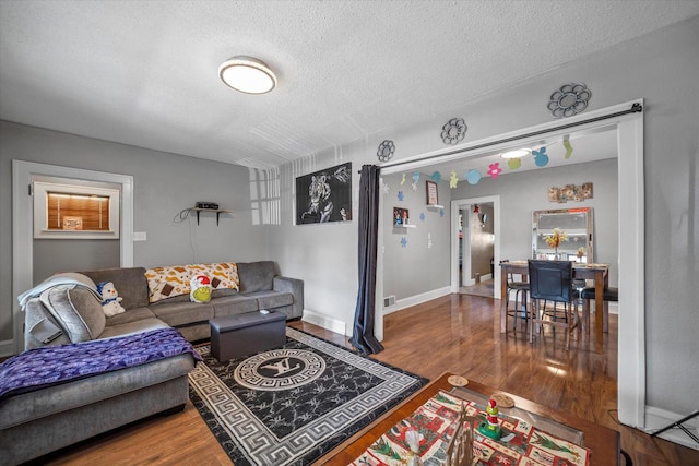 living room featuring wood-type flooring and a textured ceiling