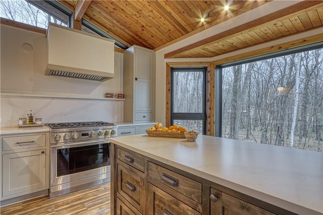 kitchen with stainless steel range, vaulted ceiling with beams, extractor fan, light hardwood / wood-style floors, and wood ceiling