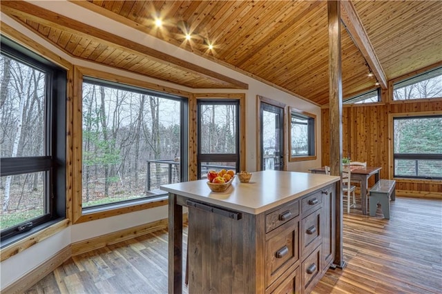 kitchen featuring a kitchen island, wooden ceiling, light hardwood / wood-style flooring, and a healthy amount of sunlight