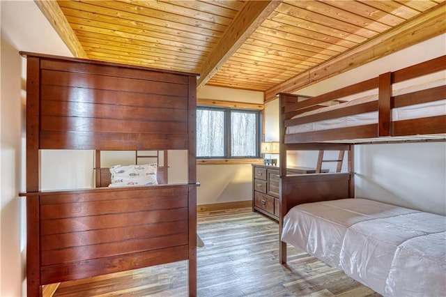 bedroom with beamed ceiling, light hardwood / wood-style flooring, and wood ceiling