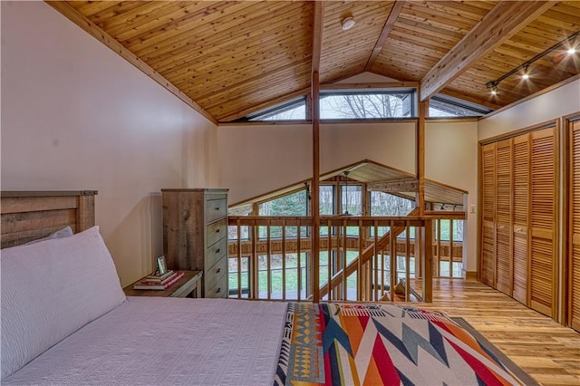 bedroom with beam ceiling, high vaulted ceiling, hardwood / wood-style floors, a closet, and wood ceiling