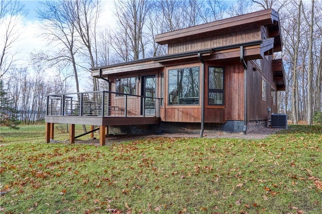 view of home's exterior with central AC, a yard, and a deck