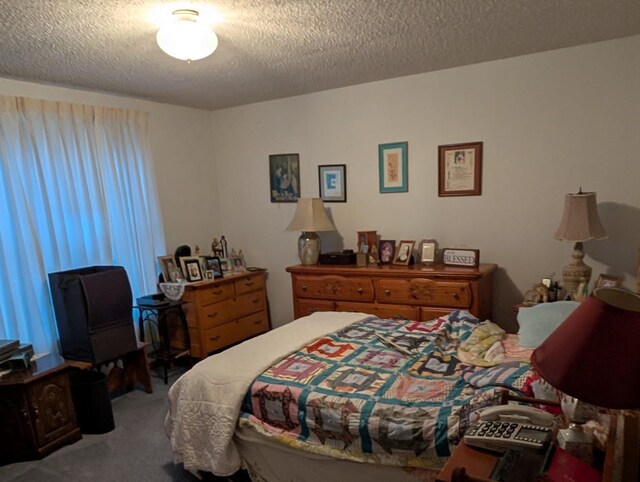 bedroom featuring carpet flooring and a textured ceiling