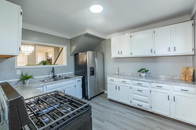 kitchen with white cabinets, appliances with stainless steel finishes, light hardwood / wood-style flooring, and sink