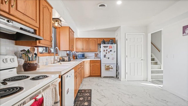 kitchen featuring vaulted ceiling, white appliances, sink, and tasteful backsplash