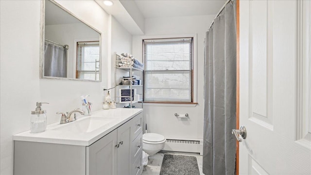 bathroom with vanity, a healthy amount of sunlight, toilet, and a baseboard radiator