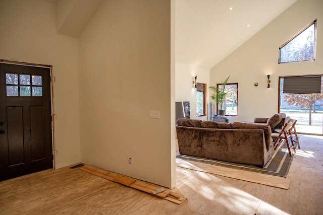 foyer entrance featuring high vaulted ceiling and light wood-type flooring