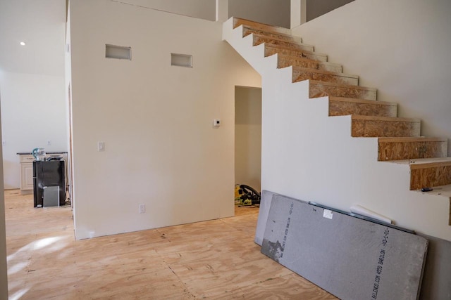 interior space featuring a towering ceiling and hardwood / wood-style flooring