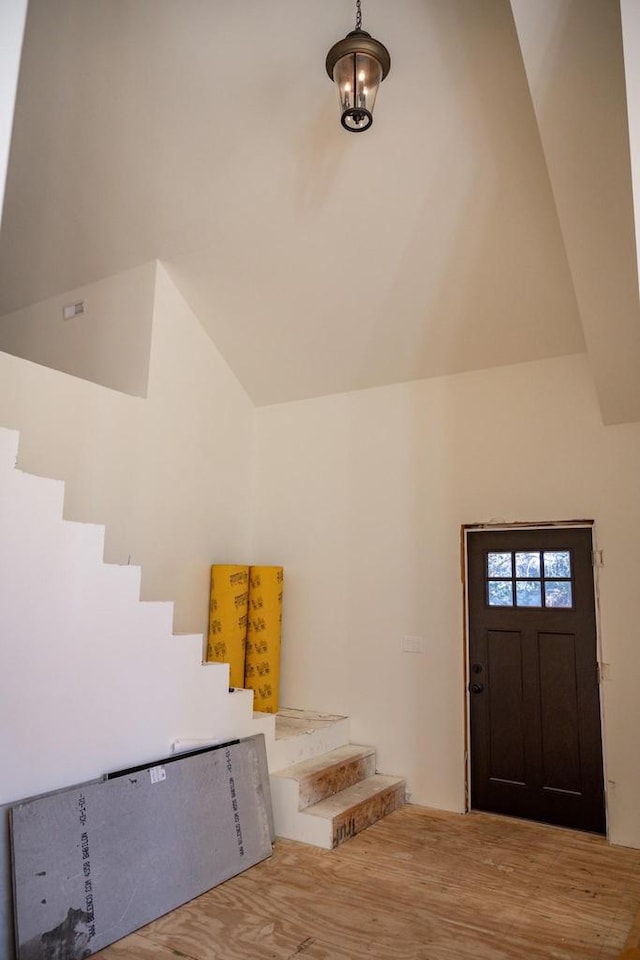 foyer featuring light wood-type flooring and vaulted ceiling