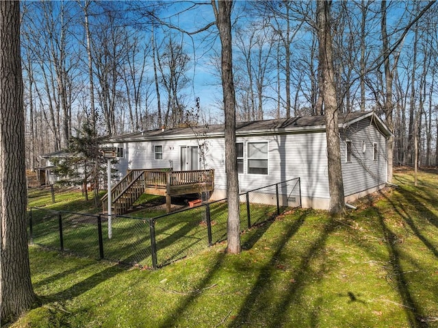 back of property featuring a lawn and a wooden deck