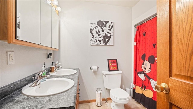 bathroom with toilet, vanity, and tile patterned floors