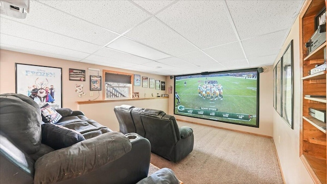 carpeted home theater room featuring a drop ceiling