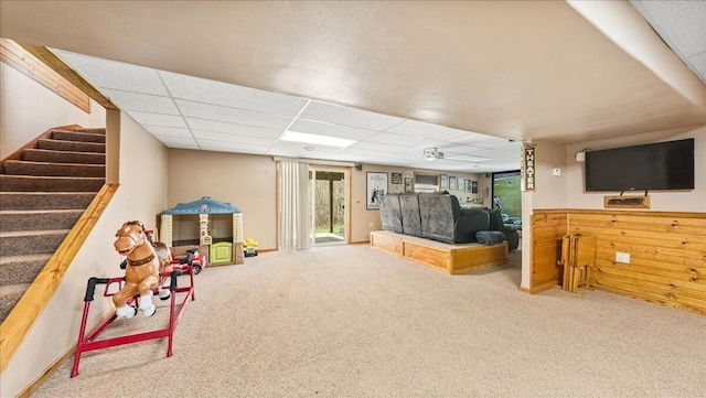 game room with a paneled ceiling and carpet flooring