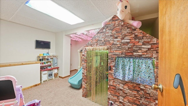 playroom with a drop ceiling and carpet