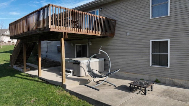 back of property featuring a lawn, a patio area, a wooden deck, and an outdoor fire pit