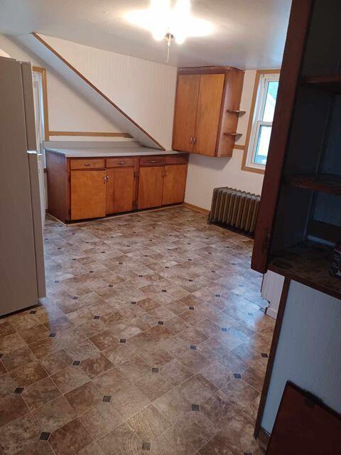 kitchen with ceiling fan, radiator heating unit, and white refrigerator