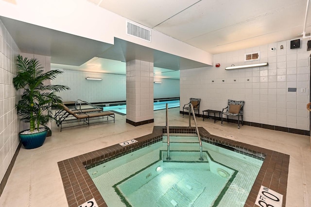 view of swimming pool featuring an indoor hot tub