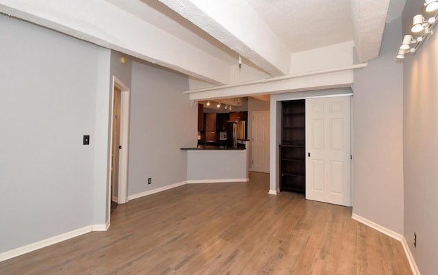 unfurnished living room featuring hardwood / wood-style floors and a textured ceiling