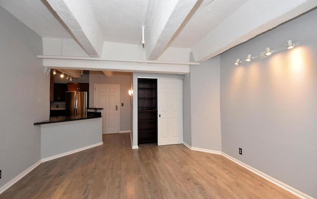 unfurnished living room featuring hardwood / wood-style floors and a textured ceiling