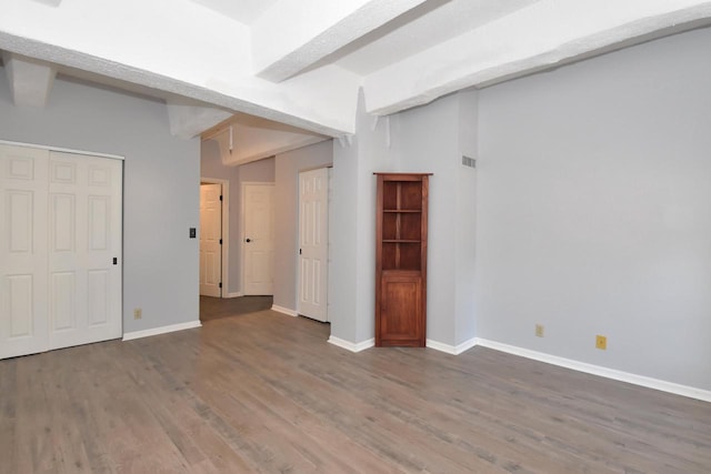 interior space featuring beam ceiling and dark wood-type flooring