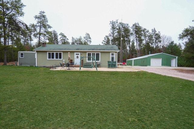 single story home with a garage, a patio area, an outbuilding, and a front lawn