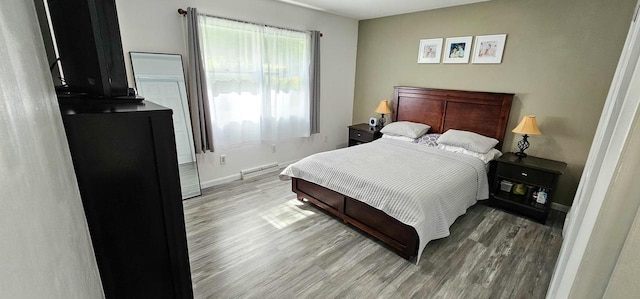 bedroom with a baseboard radiator and light wood-type flooring