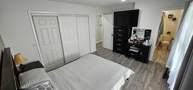 bedroom with dark hardwood / wood-style flooring, a closet, and ensuite bath