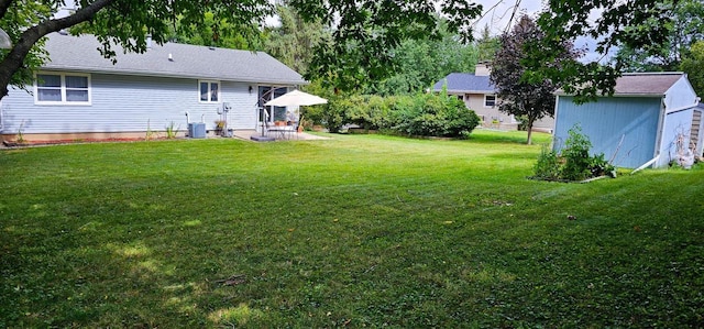 view of yard featuring cooling unit, a shed, and a patio