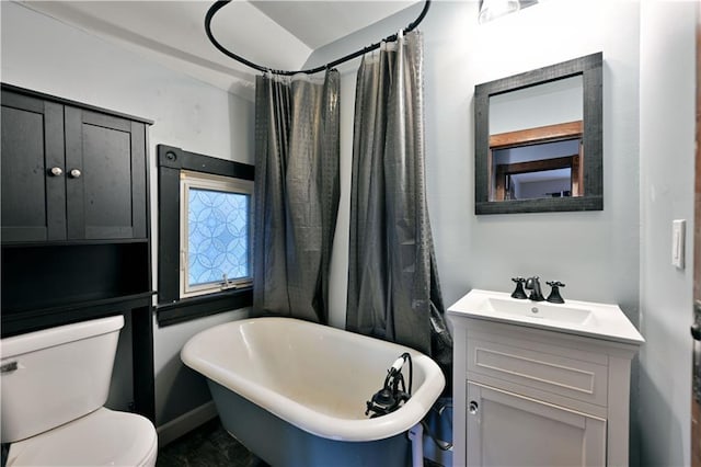 bathroom with a tub, vanity, and toilet