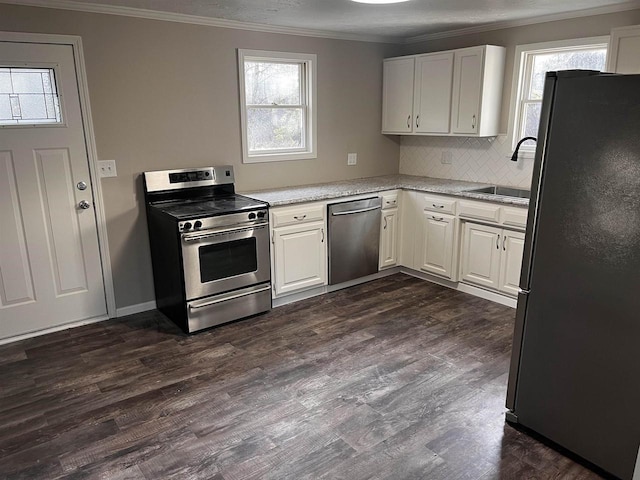 kitchen featuring sink, decorative backsplash, appliances with stainless steel finishes, dark hardwood / wood-style flooring, and white cabinetry