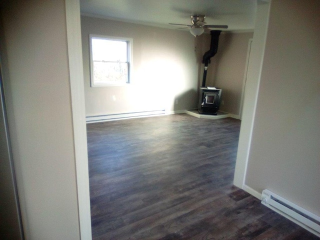 unfurnished living room featuring a wood stove, baseboard heating, dark wood-type flooring, and ceiling fan