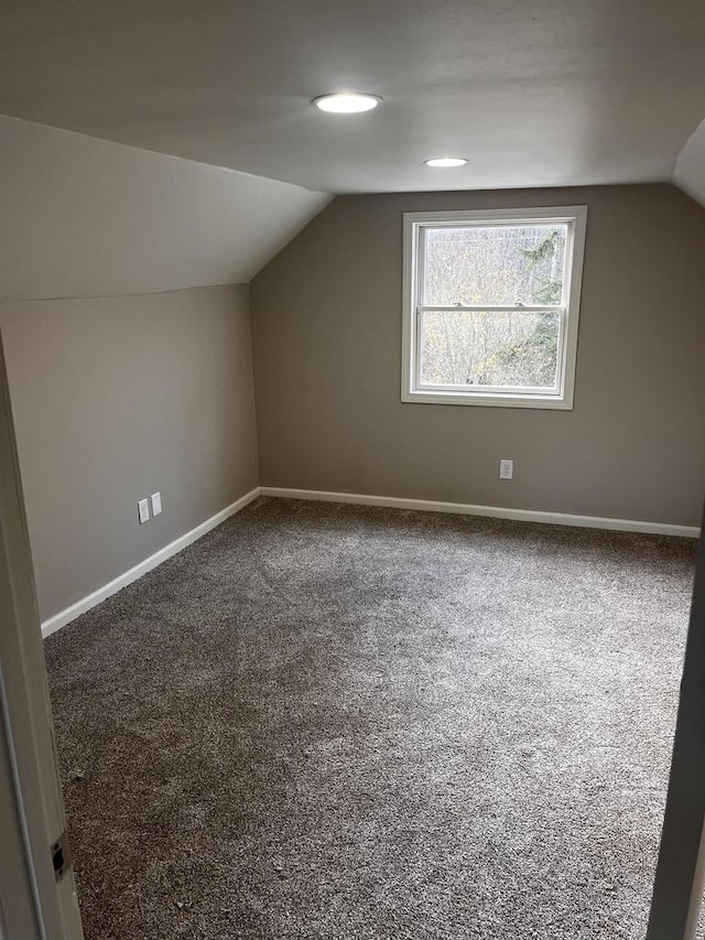 bonus room with carpet flooring and vaulted ceiling