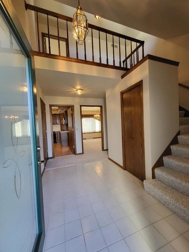 tiled entrance foyer featuring a high ceiling and an inviting chandelier