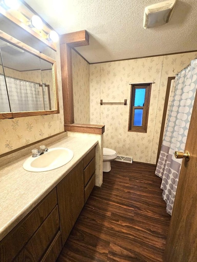 bathroom with hardwood / wood-style floors, vanity, a textured ceiling, and toilet