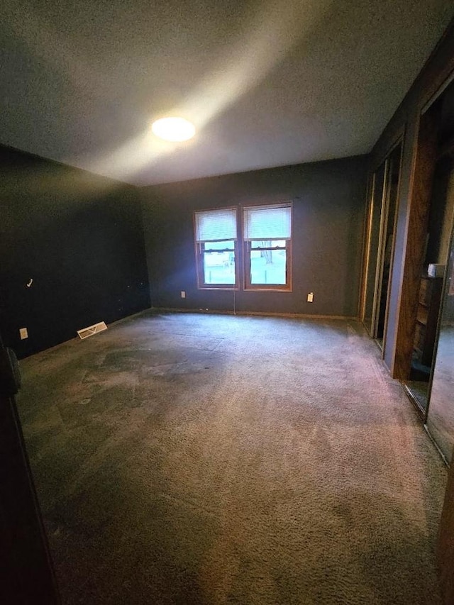 spare room with carpet floors and a textured ceiling