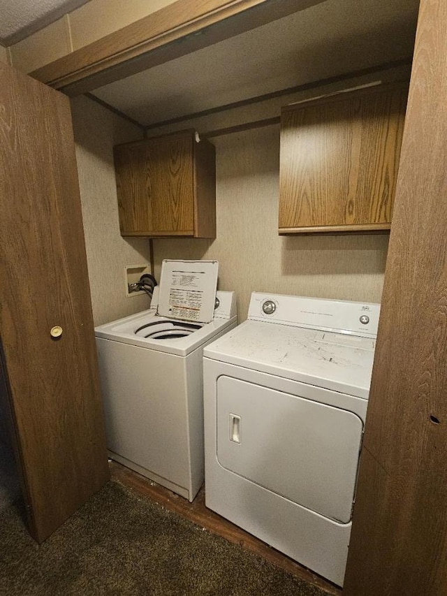 clothes washing area featuring washing machine and dryer and cabinets