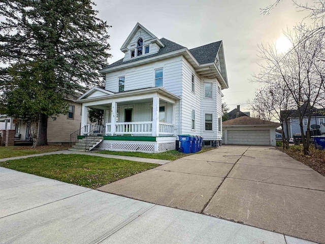 view of front facade featuring a front yard, a porch, a garage, and an outdoor structure