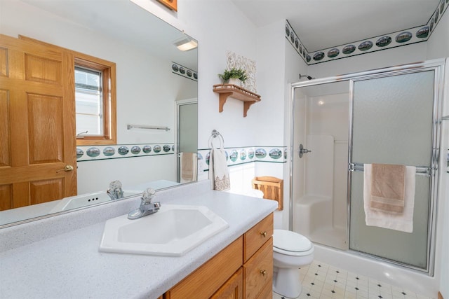 bathroom with walk in shower, vanity, and toilet