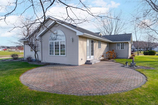 back of property featuring a patio area and a lawn