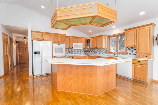 kitchen with pendant lighting, sink, white appliances, and a center island