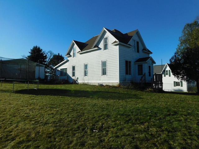 view of home's exterior with a yard and a trampoline